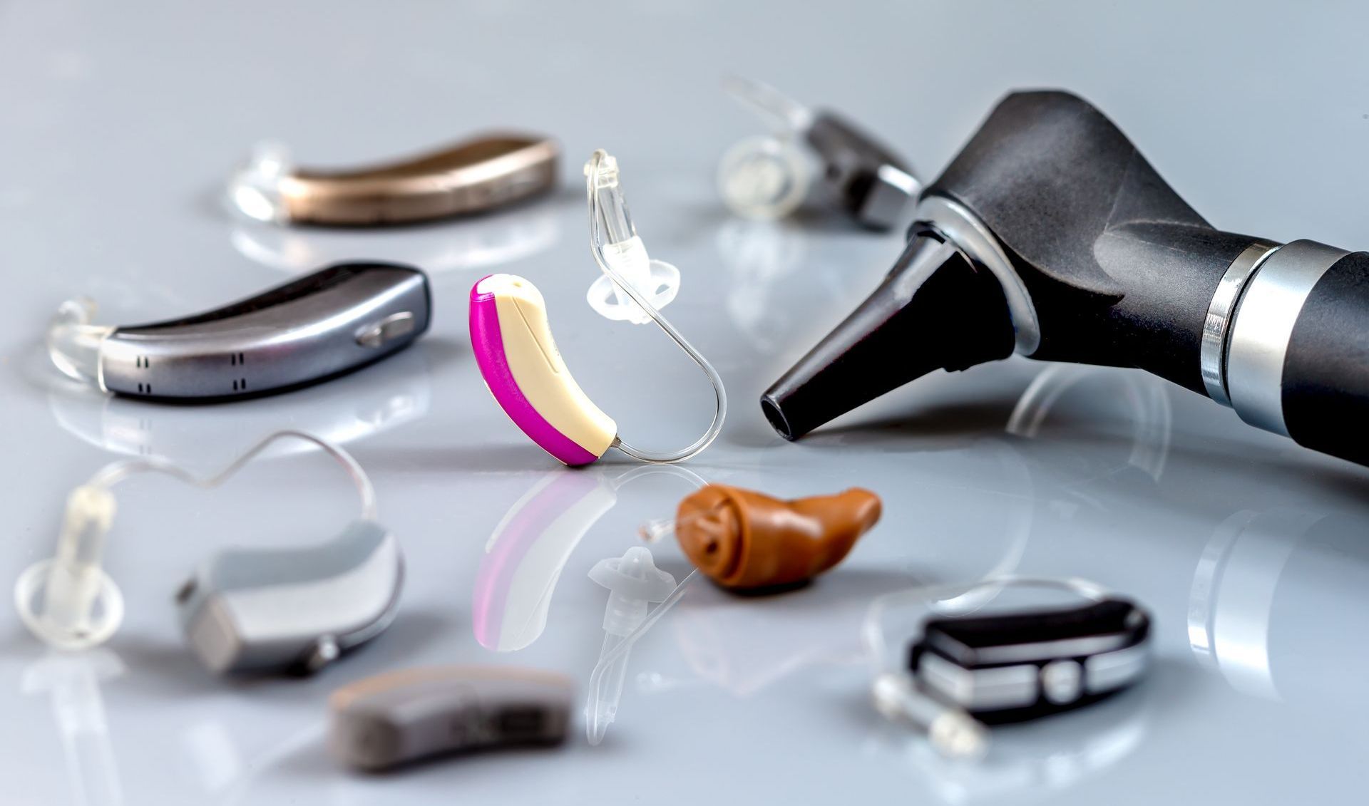 There are many different types of hearing aids on the table.