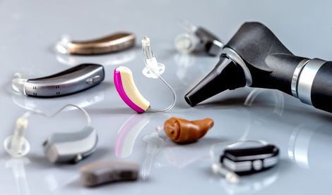 There are many different types of hearing aids on the table.