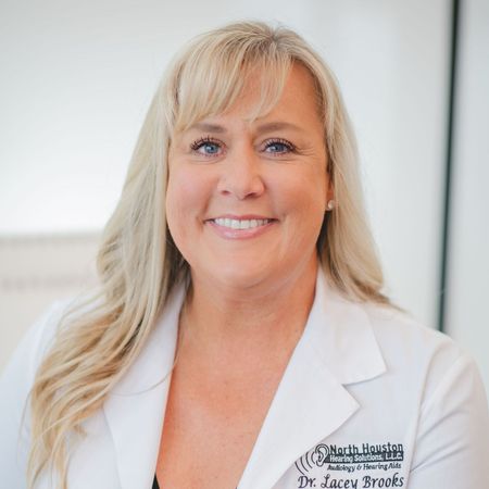 A woman wearing a white lab coat with the name lacey brooks on it