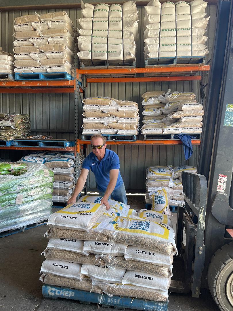 Man Putting Sacks of Poultry Product — Produce Store in Tamworth, NSW