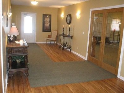 A hallway with hardwood floors and a clock on the wall