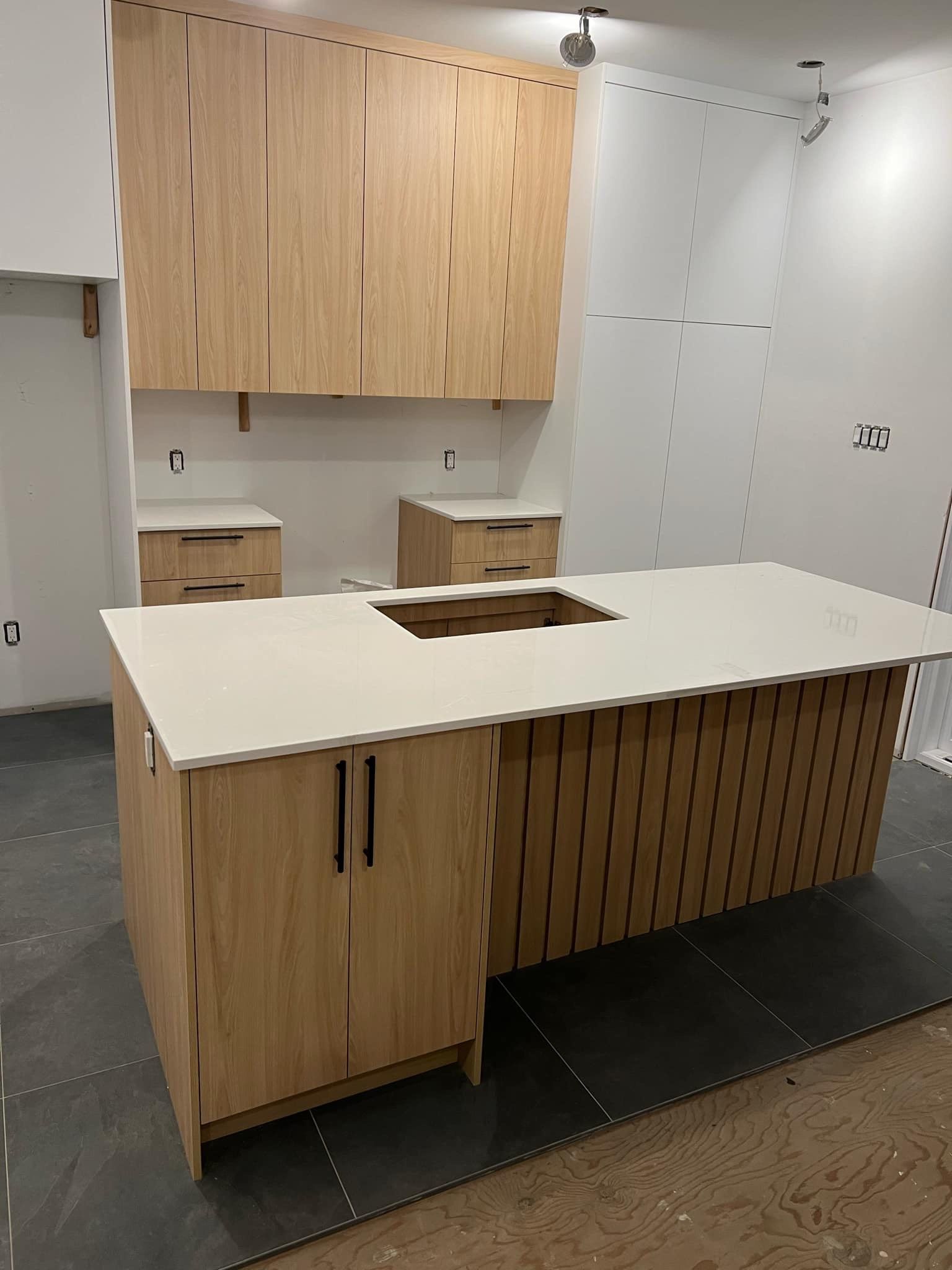 Une cuisine avec des armoires en bois et un grand îlot au milieu.