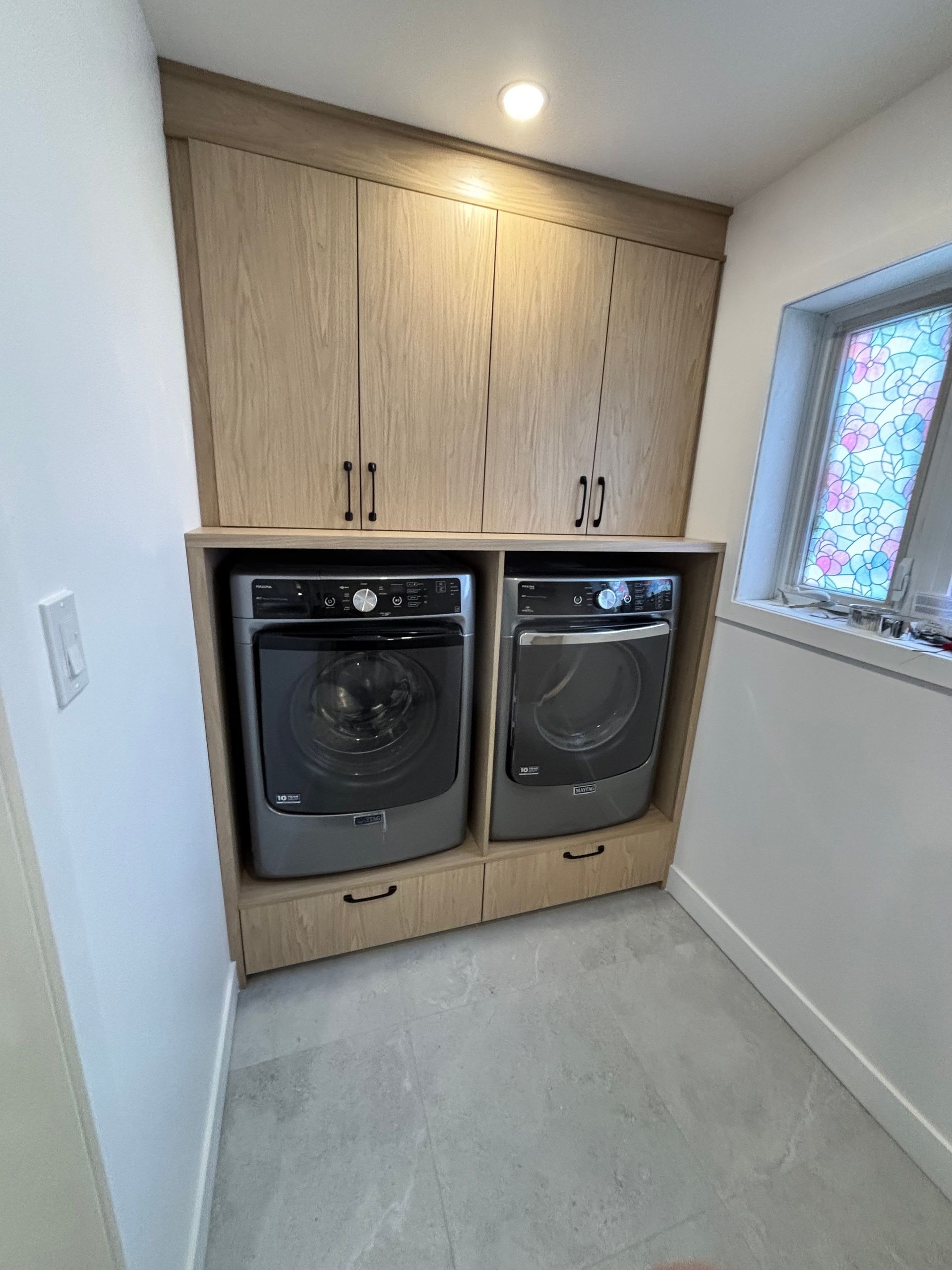 Une buanderie avec une laveuse et une sécheuse à l'intérieur.