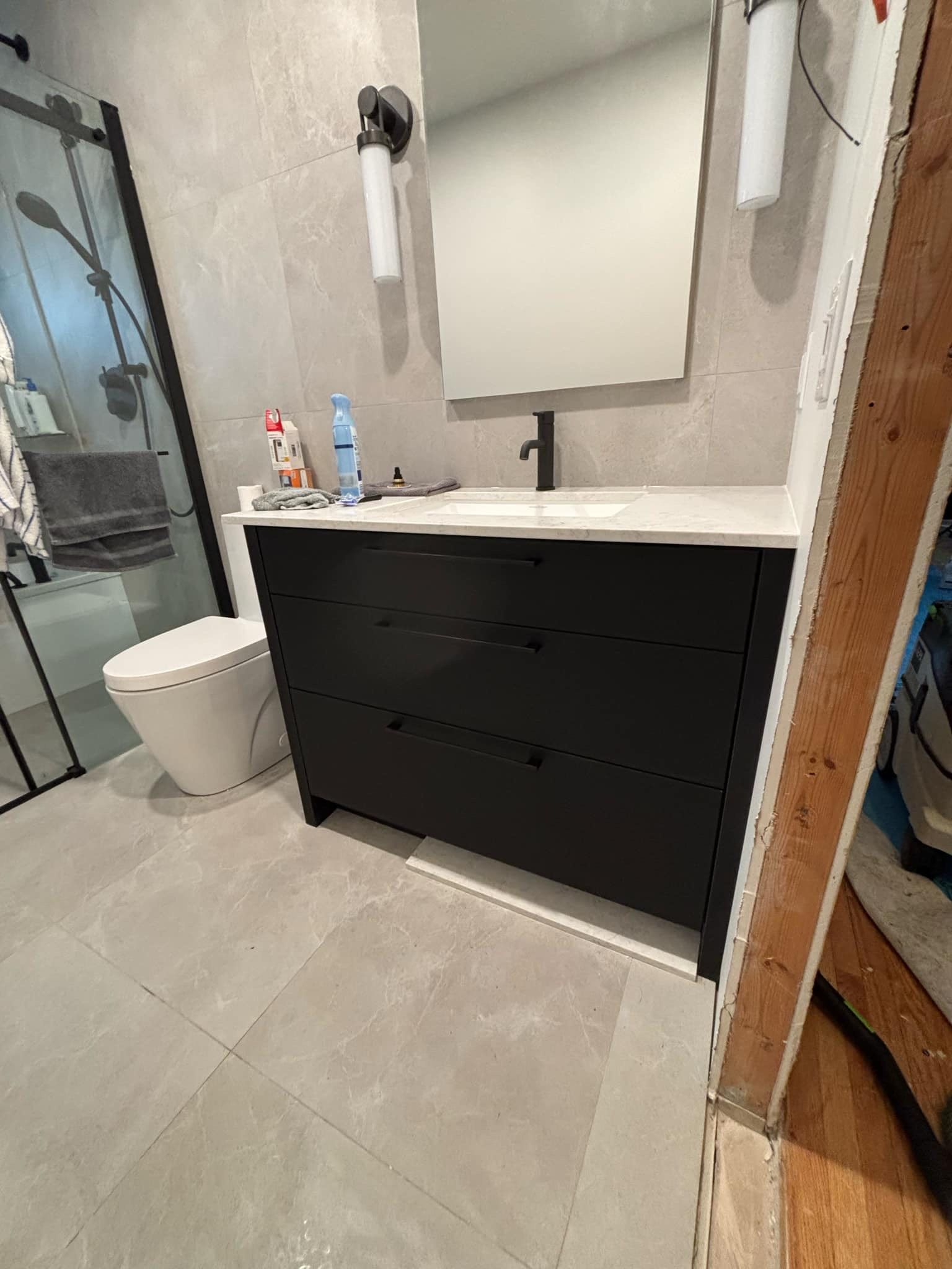 Une salle de bain avec lavabo, WC et miroir.