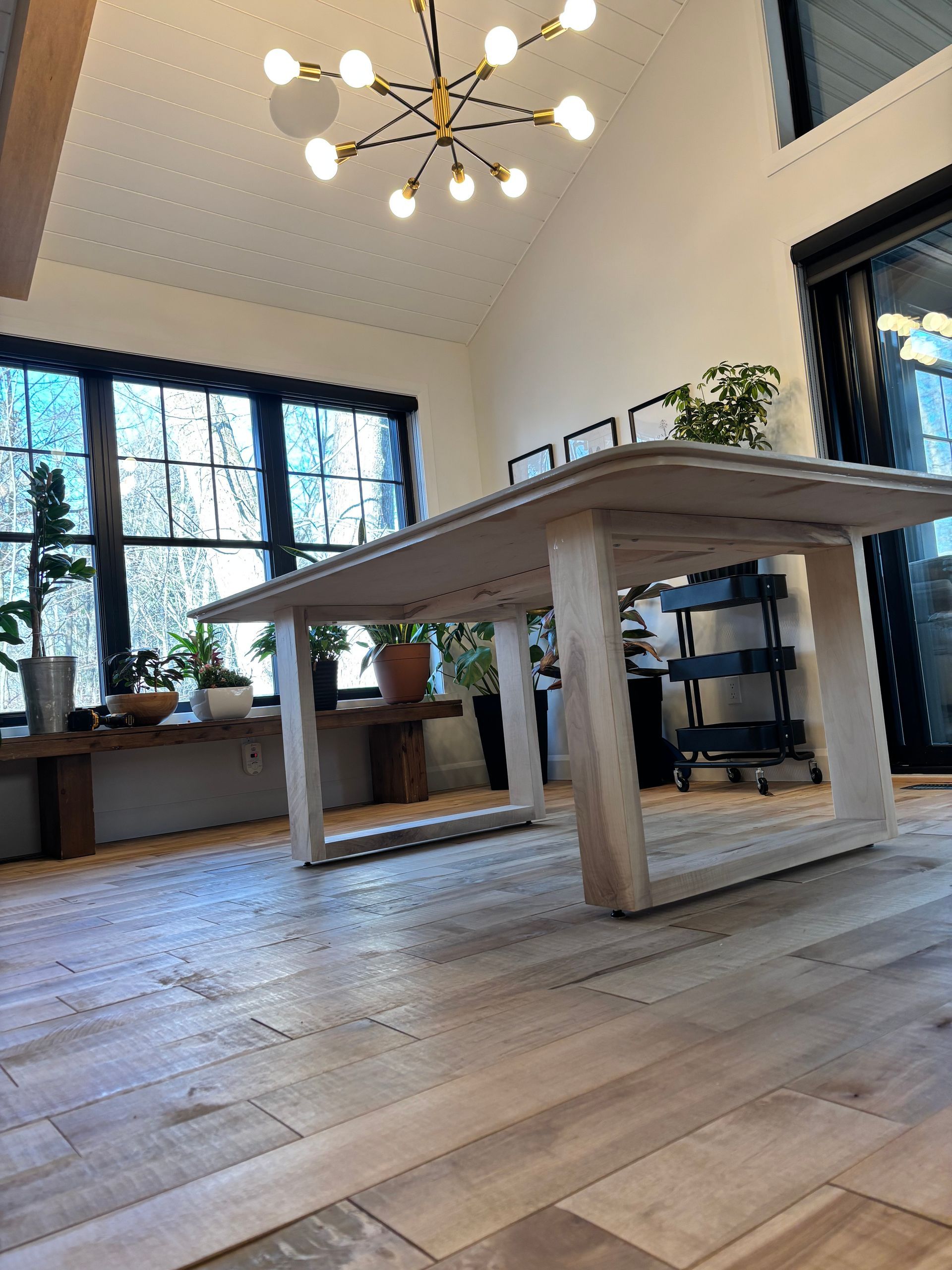 Il y a une table au milieu de la pièce avec un lustre suspendu au plafond.