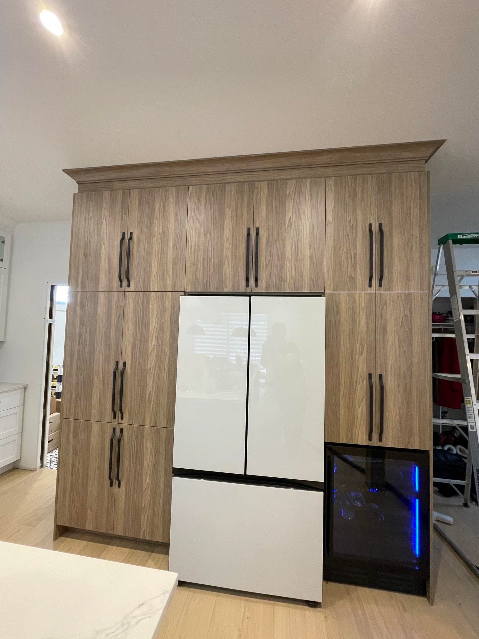 Une cuisine avec des armoires en bois et un réfrigérateur.