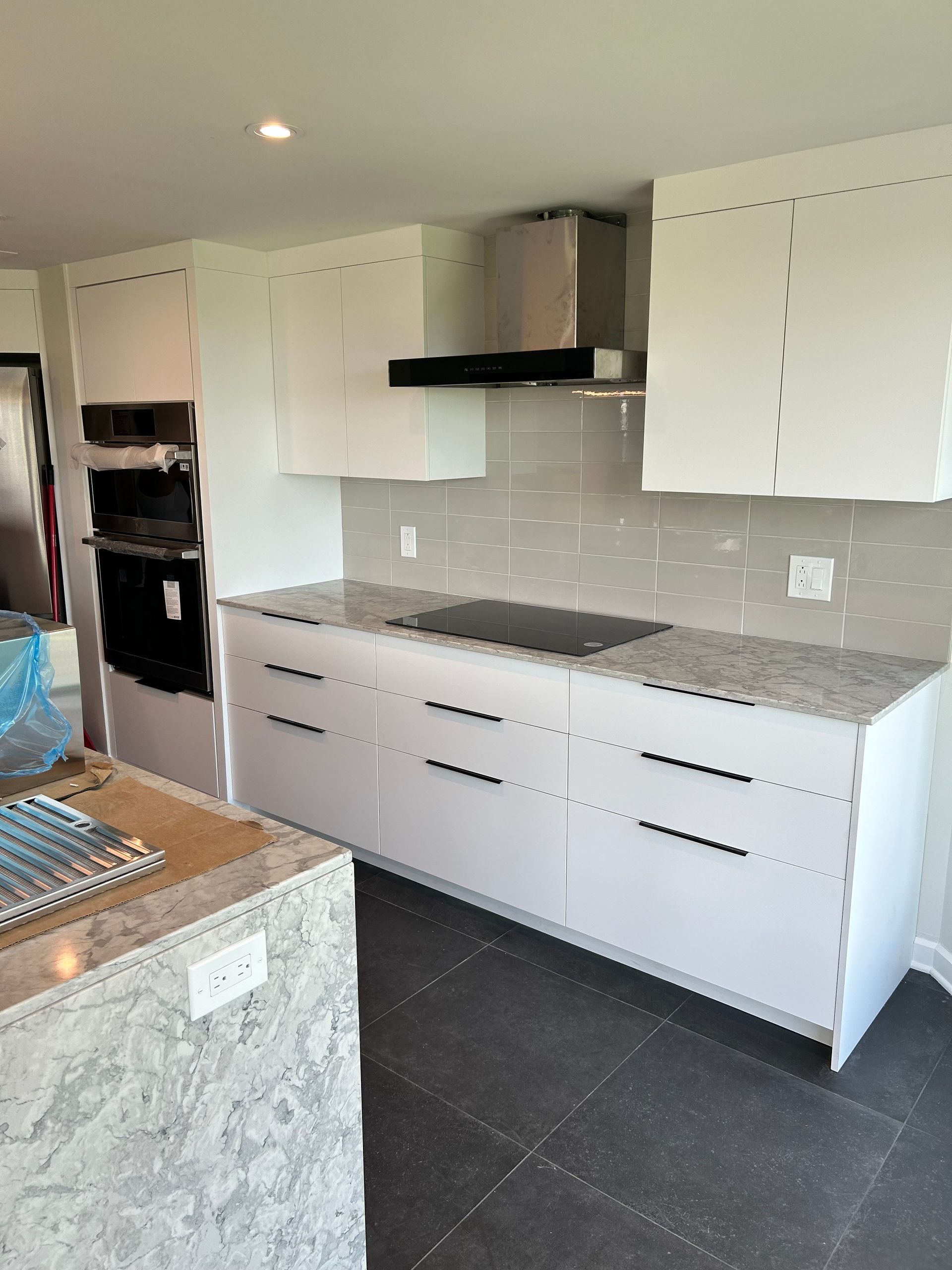 Une cuisine avec des armoires blanches et des comptoirs en granit