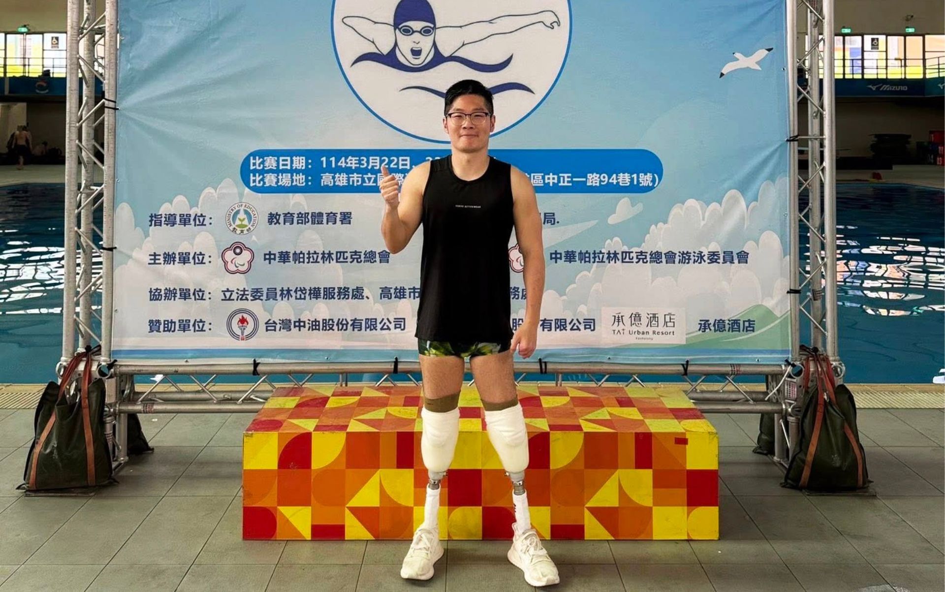 永純之友正全：站在游泳池畔的活動背板前，呈現泳者自信姿態。