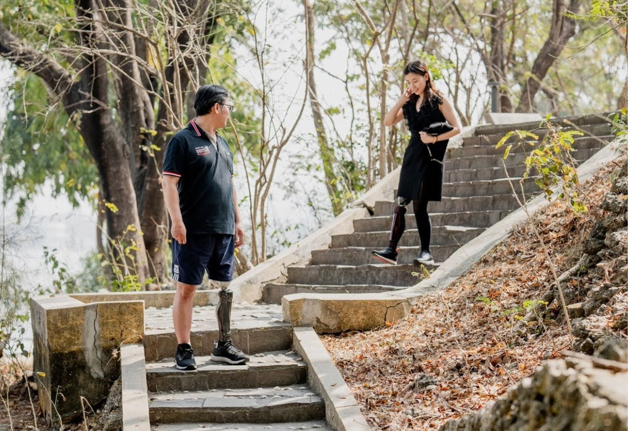 永純仿生智能腿：真實戶外生活場景，兩位使用者在階梯上穩健站立與行走，展現微處理器控制關節對不平整地形的適應力。
