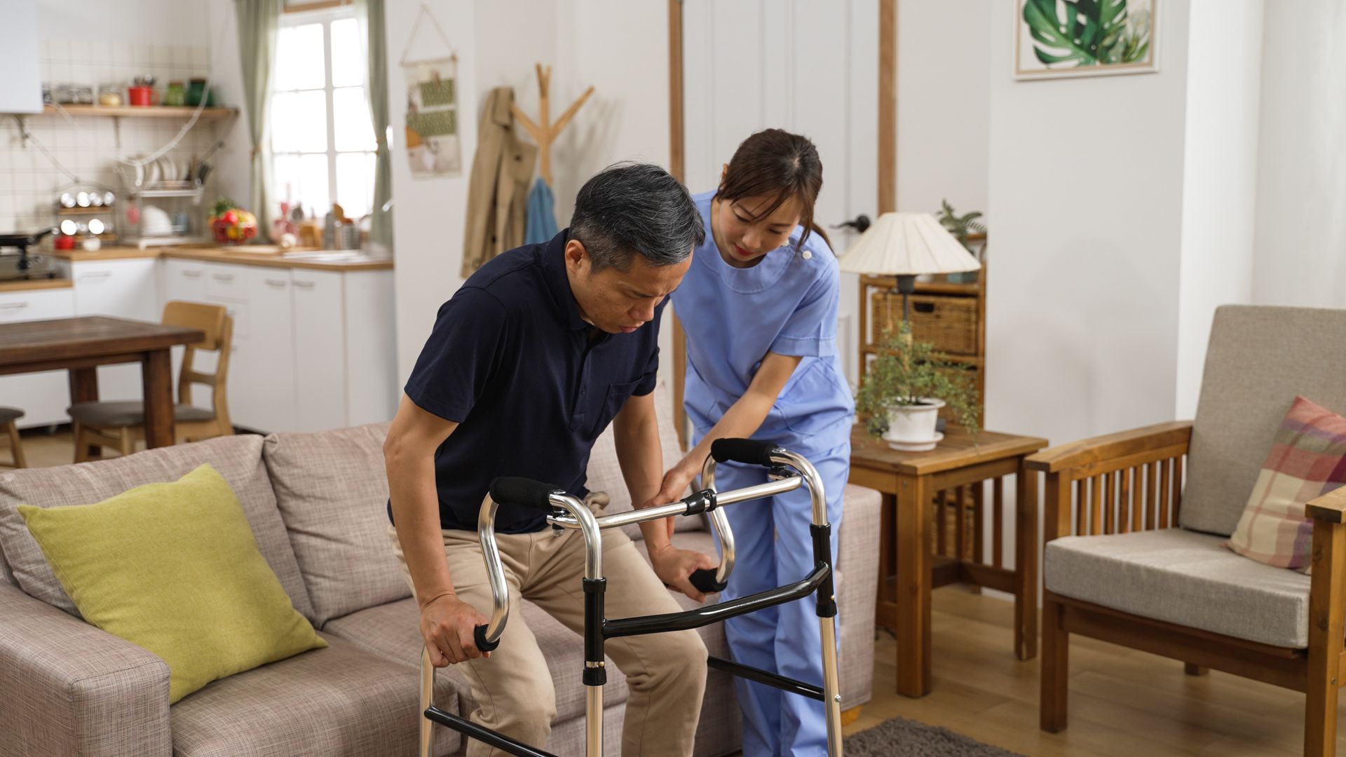 Home assistance scene with a person using a walker supported indoors in a comfortable living room.