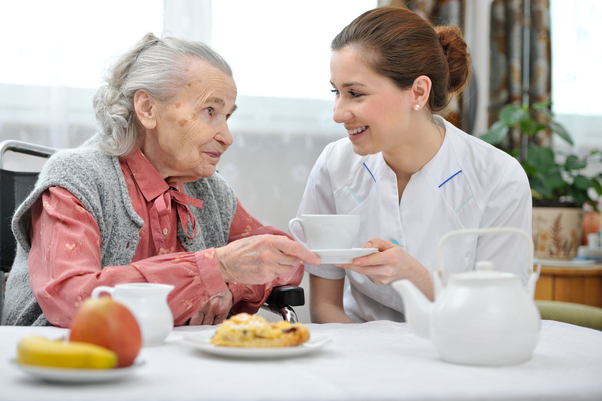 Nurse serving a tea to an senior