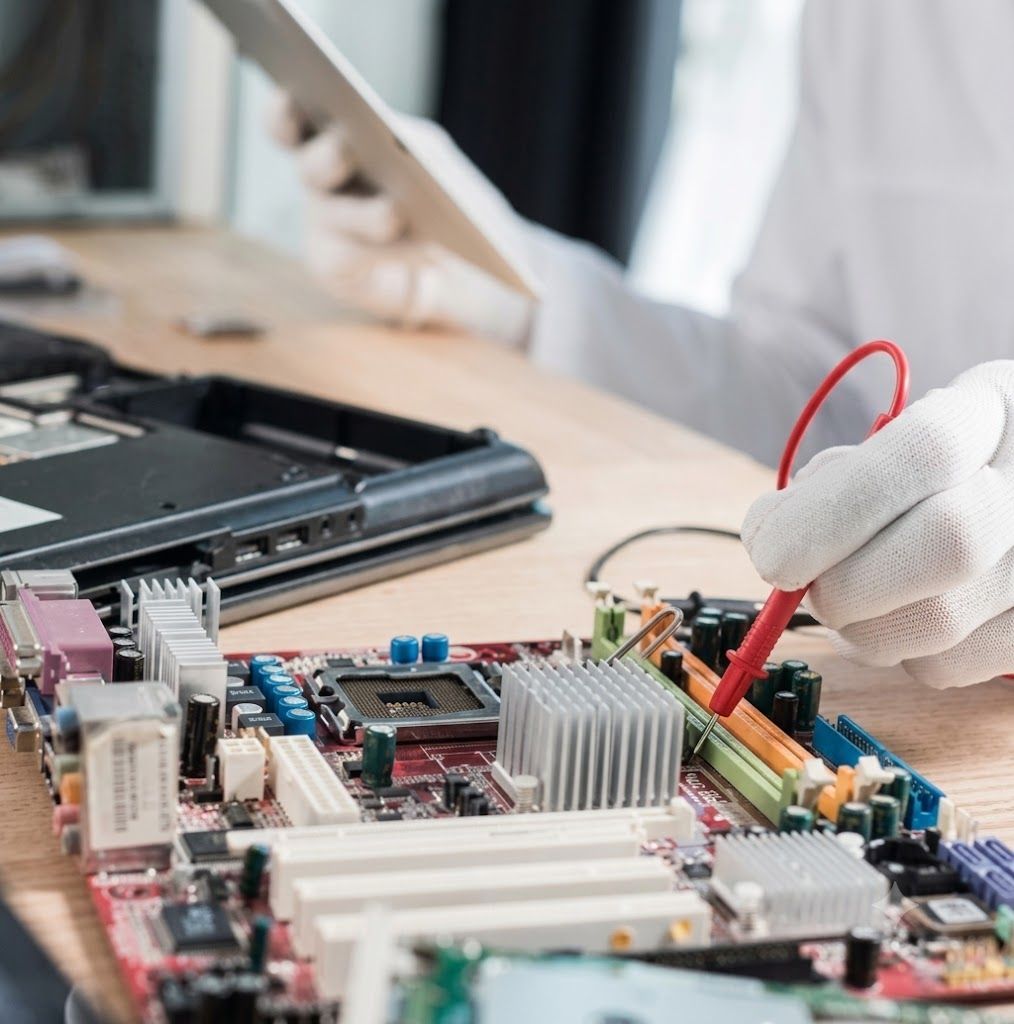 Gloved hands install a gold RAM module into a computer motherboard.