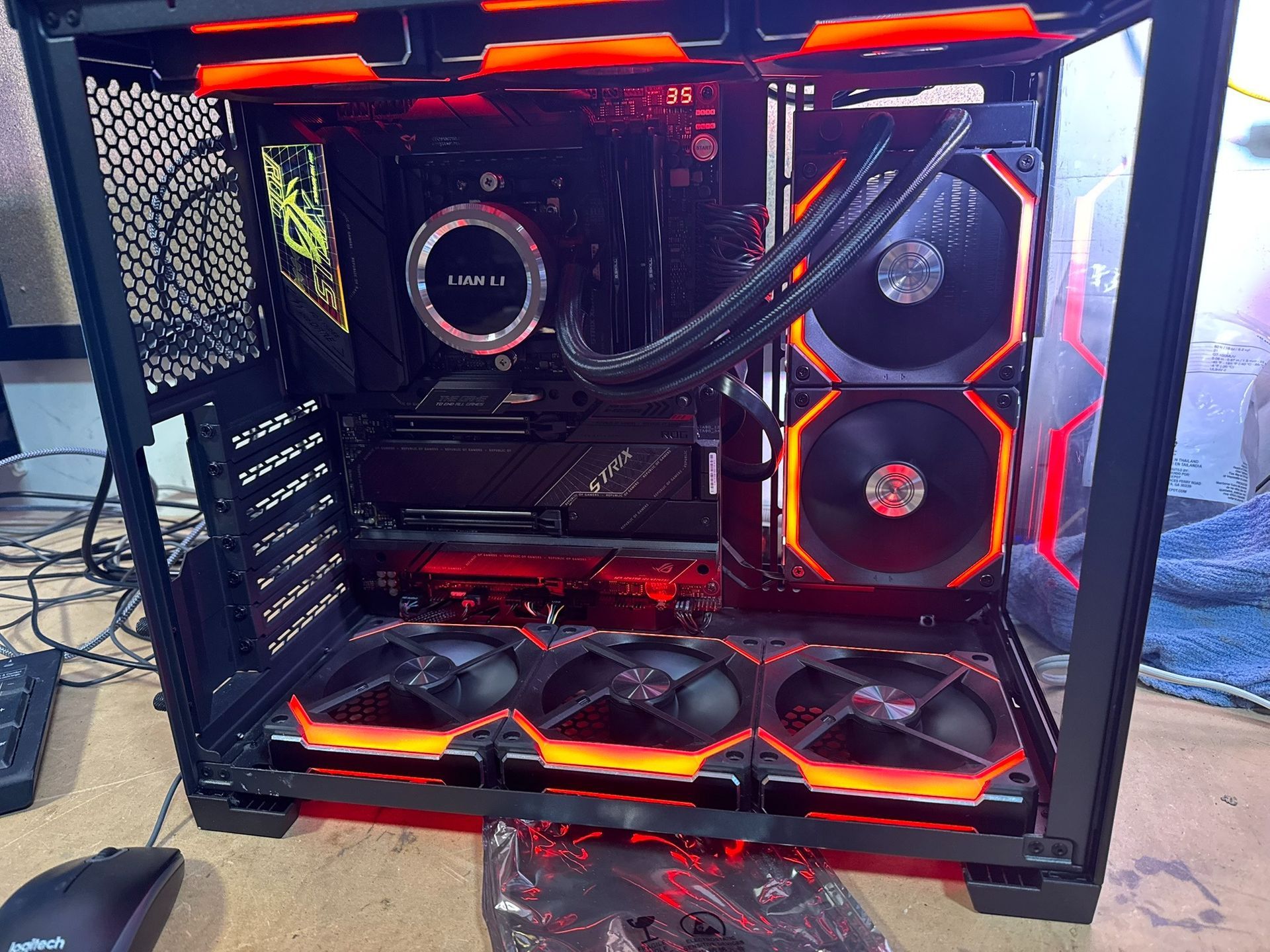 Custom gaming PC with red LED fans and liquid cooling inside a glass-sided case.