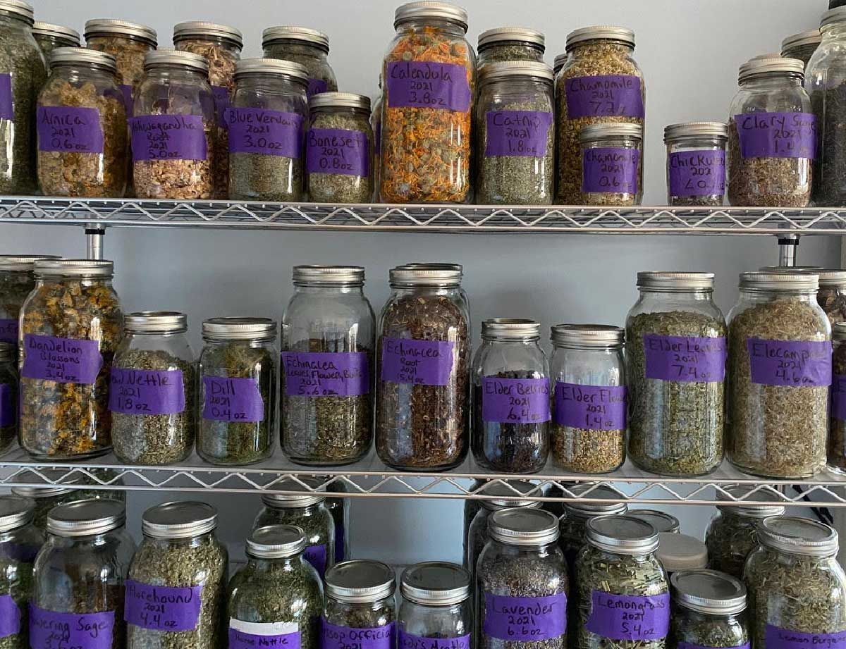 Wall of dried herbs in mason jars in the herb loft apothecary
