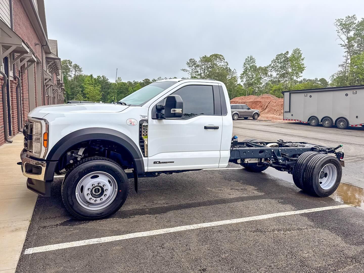 A white Ford F-Series chassis cab truck parked in a paved lot.