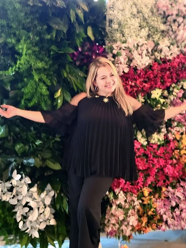 image of Yola Guz in front of floral design