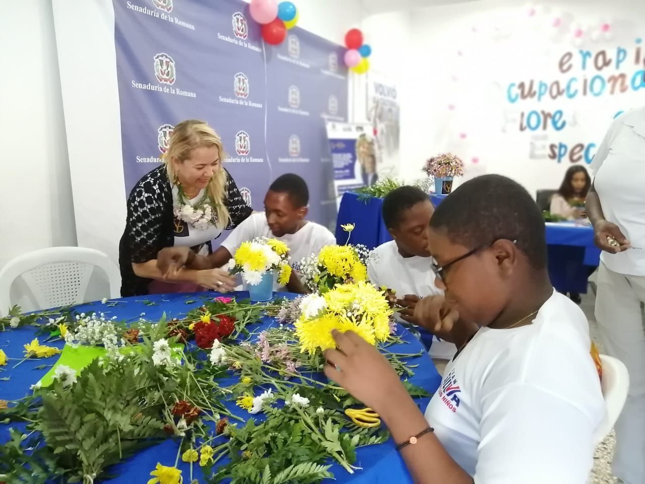 People arranging flowers at a table during a classroom craft activity