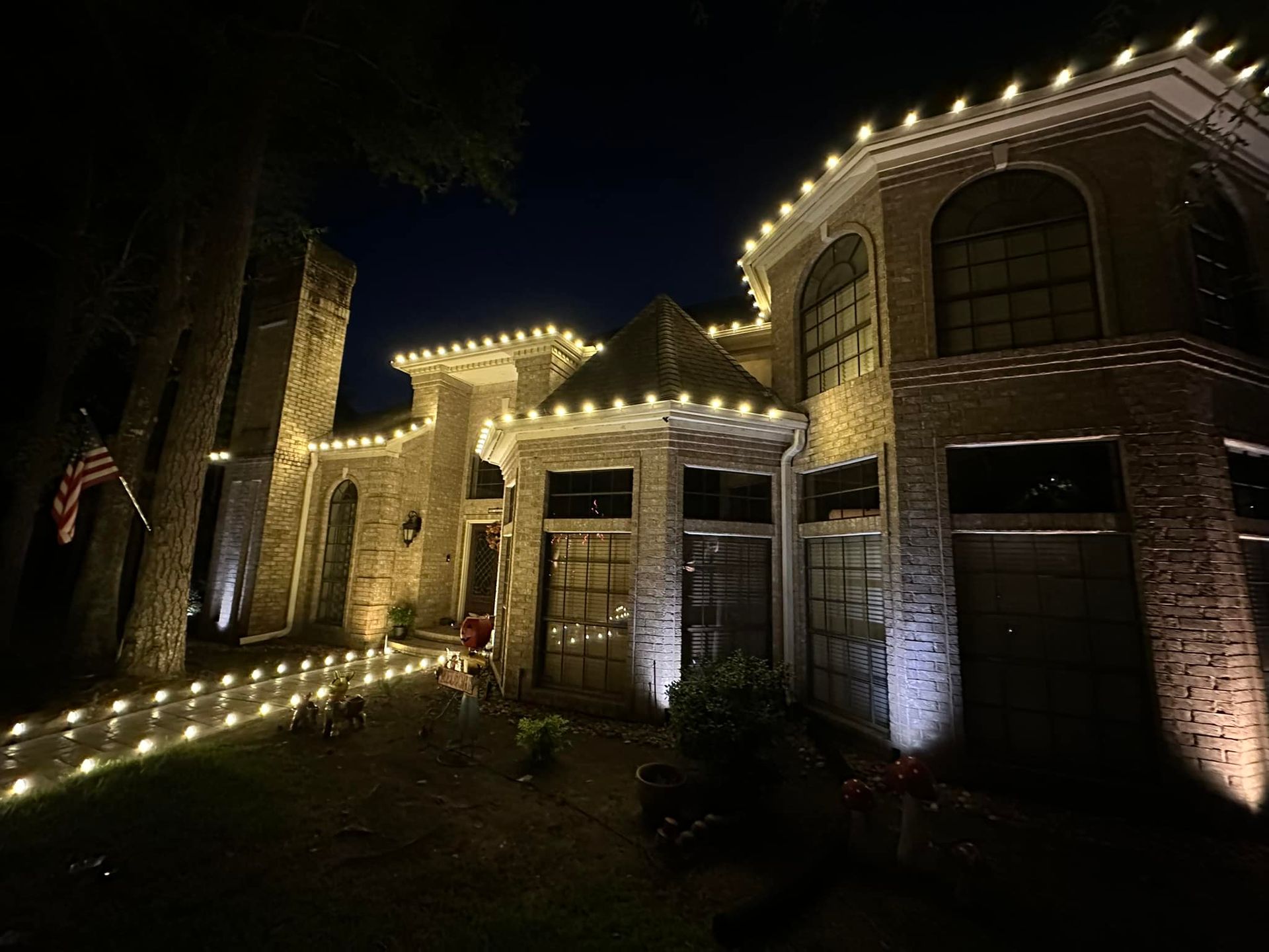 A large house is lit up with christmas lights at night.
