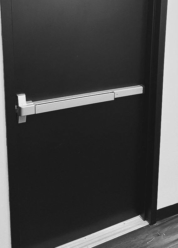 A black door with a panic bar on it.