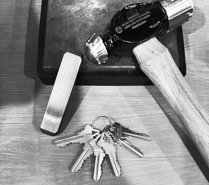 A bunch of keys and a hammer on a table