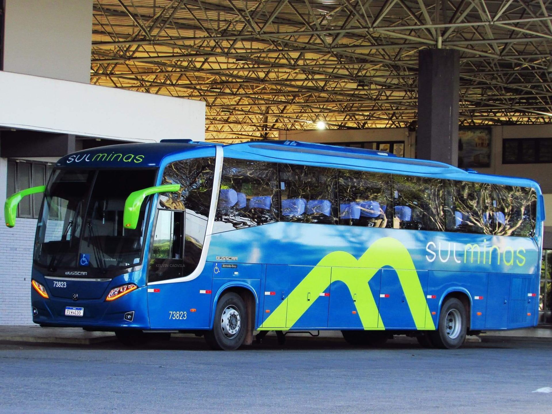 Um ônibus azul e verde na rodoviária com a palavra sul minas na lateral