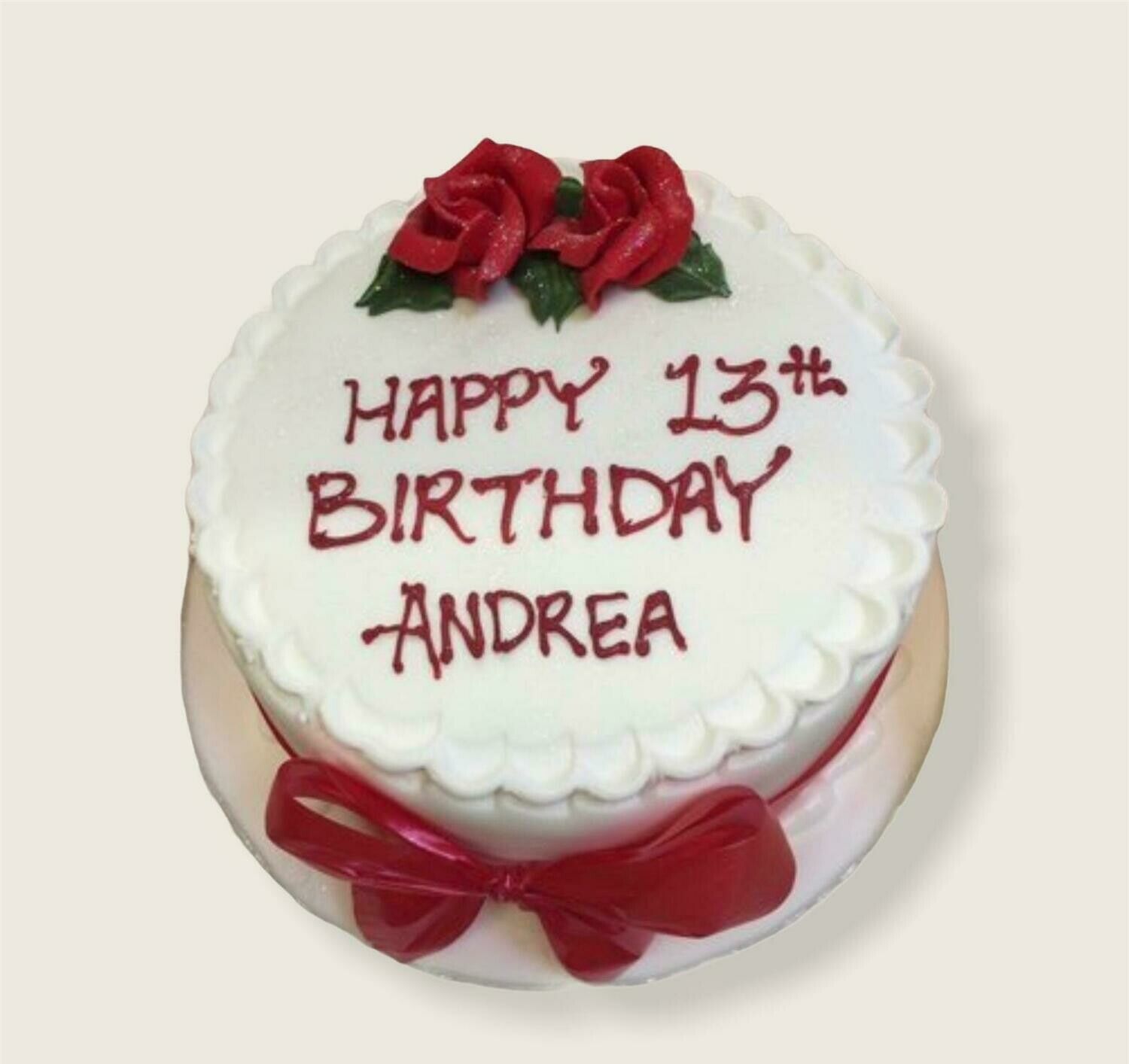 A white frosted cake decorated with two red roses on top