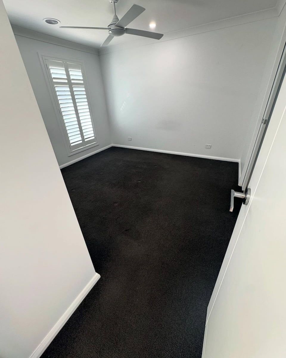Empty Room With Dark Carpeting, Light Grey Walls, a Ceiling Fan — Cobra's Carpet Cleaning in Junee, NSW