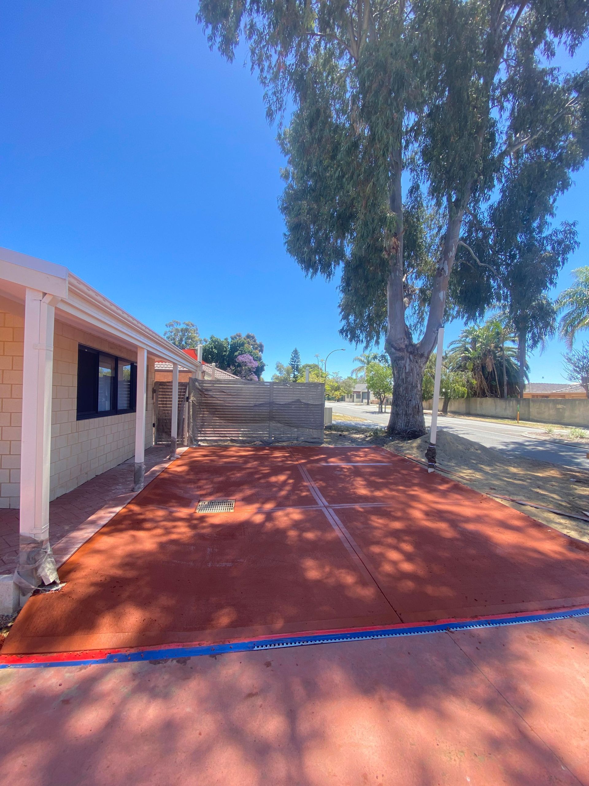 Red coloured concrete caravan shed pad next to property