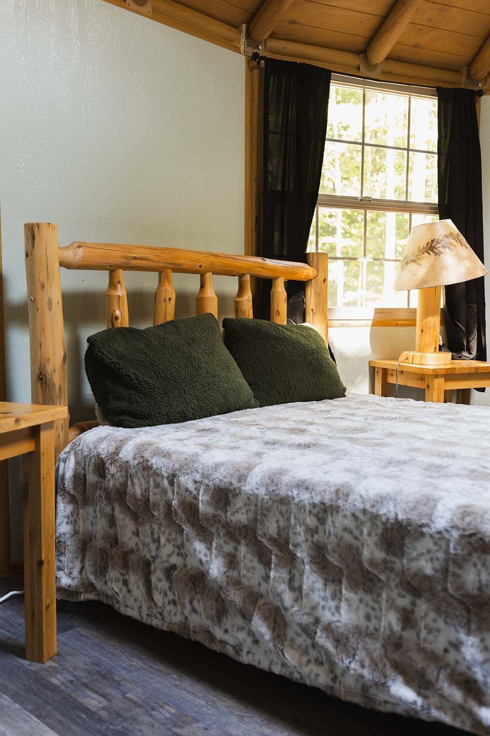 A Bedroom with A Bed , Nightstand , Lamp and Window