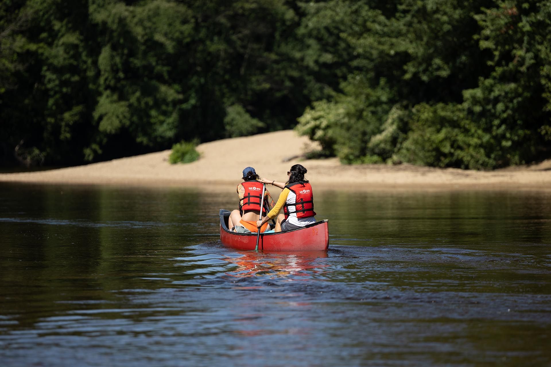 Group of People Rowing a Canoe on A River