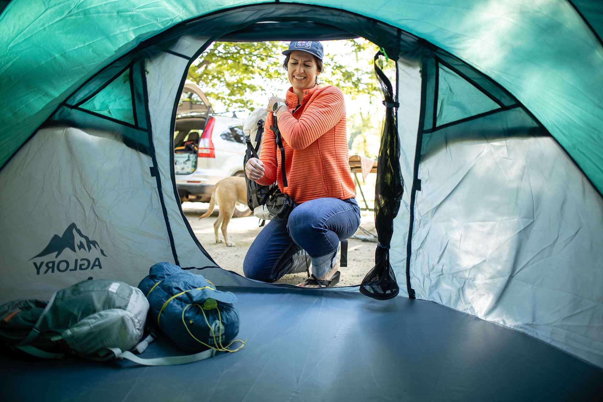 Woman Kneeling in A Tent with A Dog