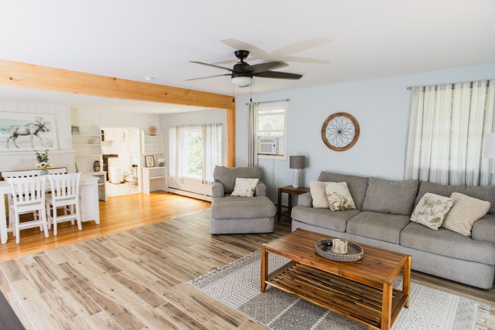 A Living Room with A Couch , Chair , Coffee Table and Ceiling Fan