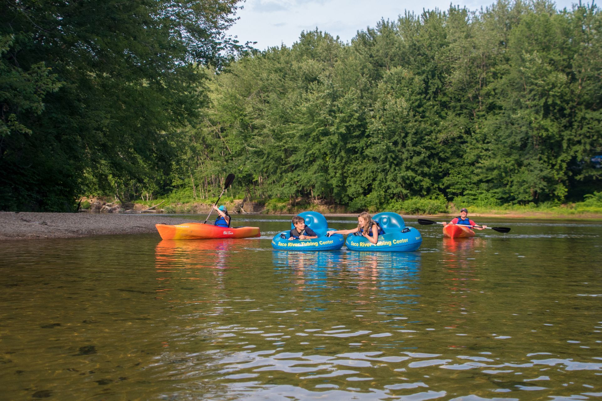 A group of people are riding pedal boats on a river.