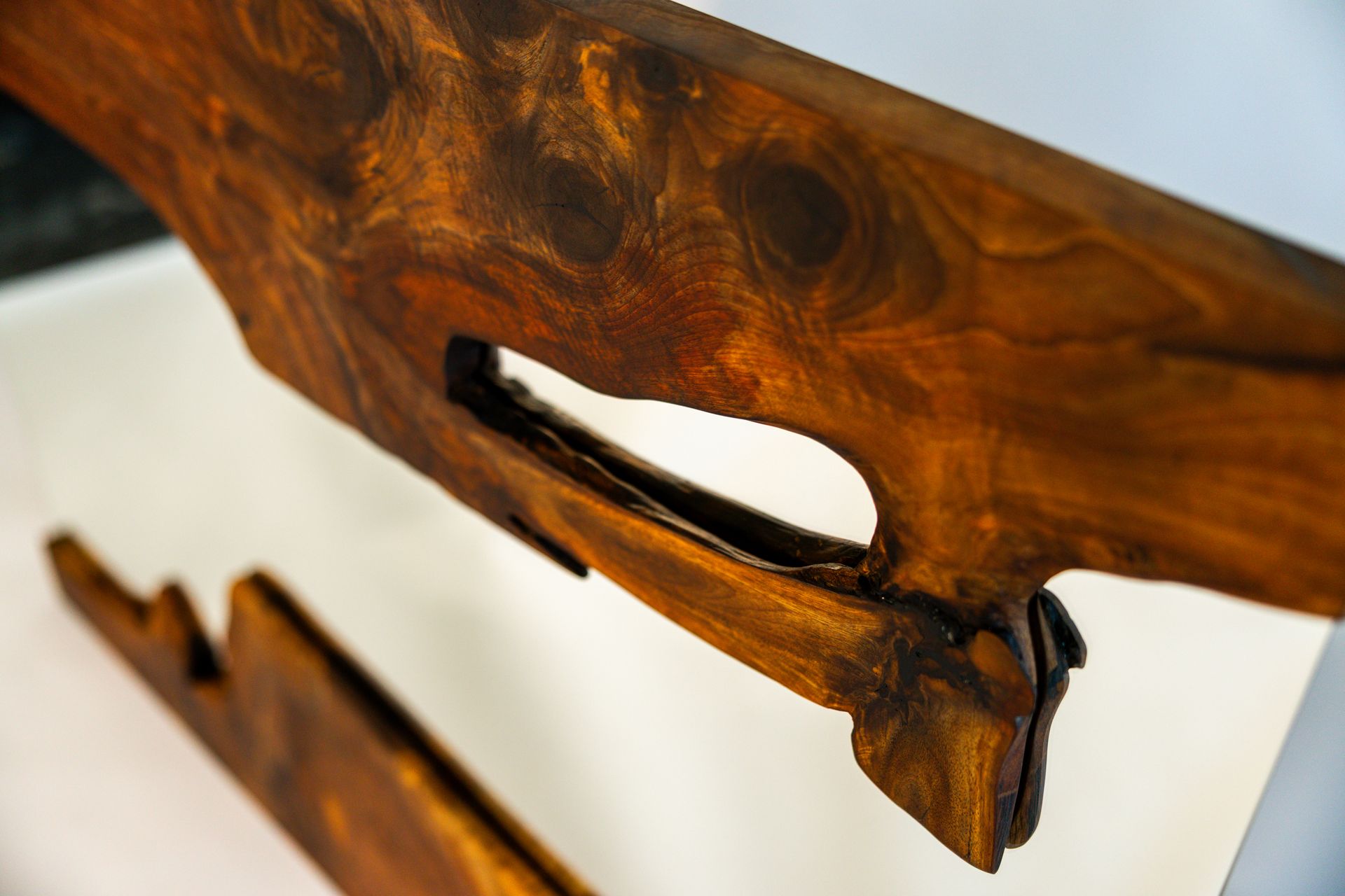 Close-up of a section of dark, finished wood with a large hole. It appears to be part of a larger structure.