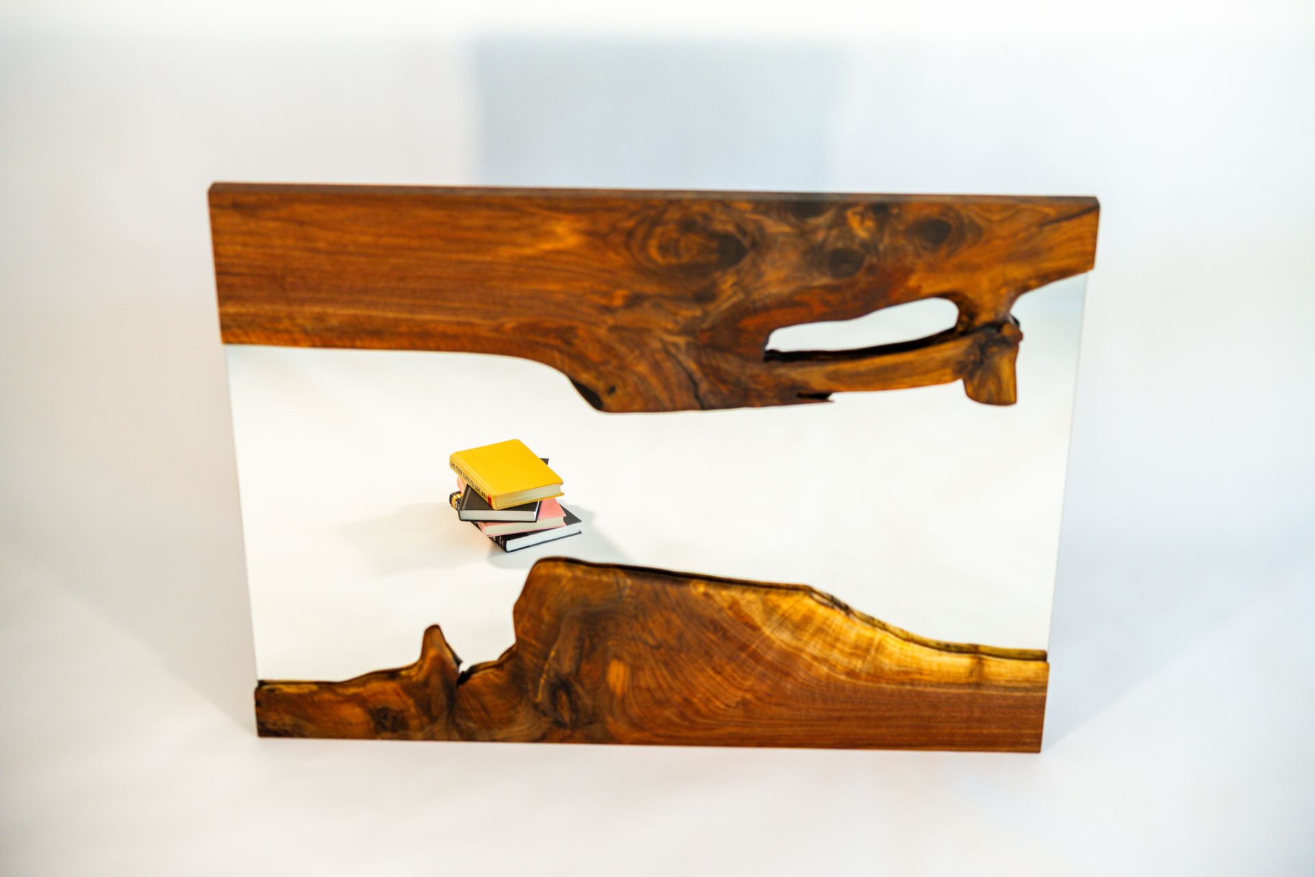 Wooden block with white resin, a small stack of books sits inside the resin.