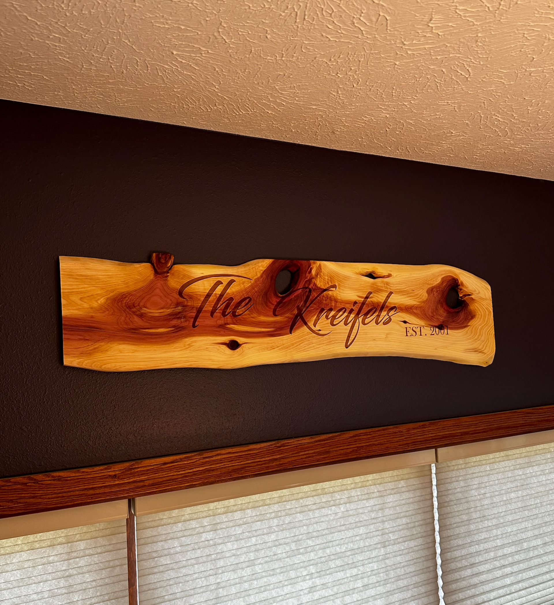 Wooden sign on a dark wall, reads 