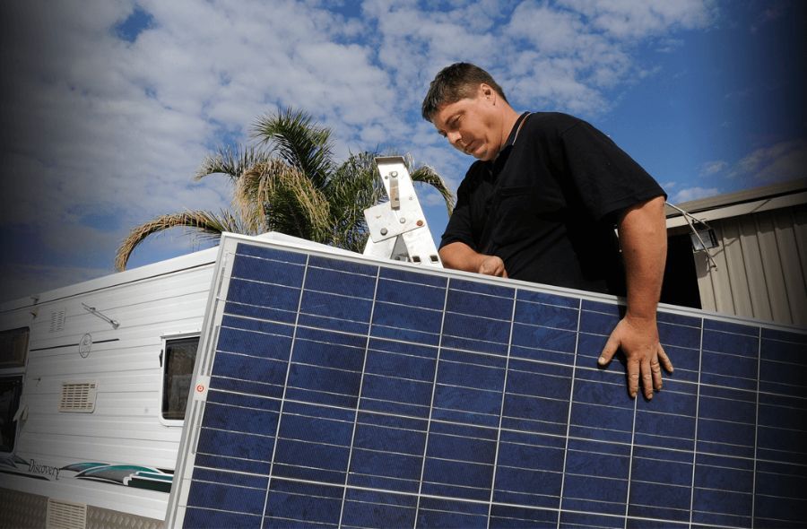 A Man is Working on a Solar Panel on Top of a Trailer — Capital Caravans Pty Ltd In Raleigh, NSW