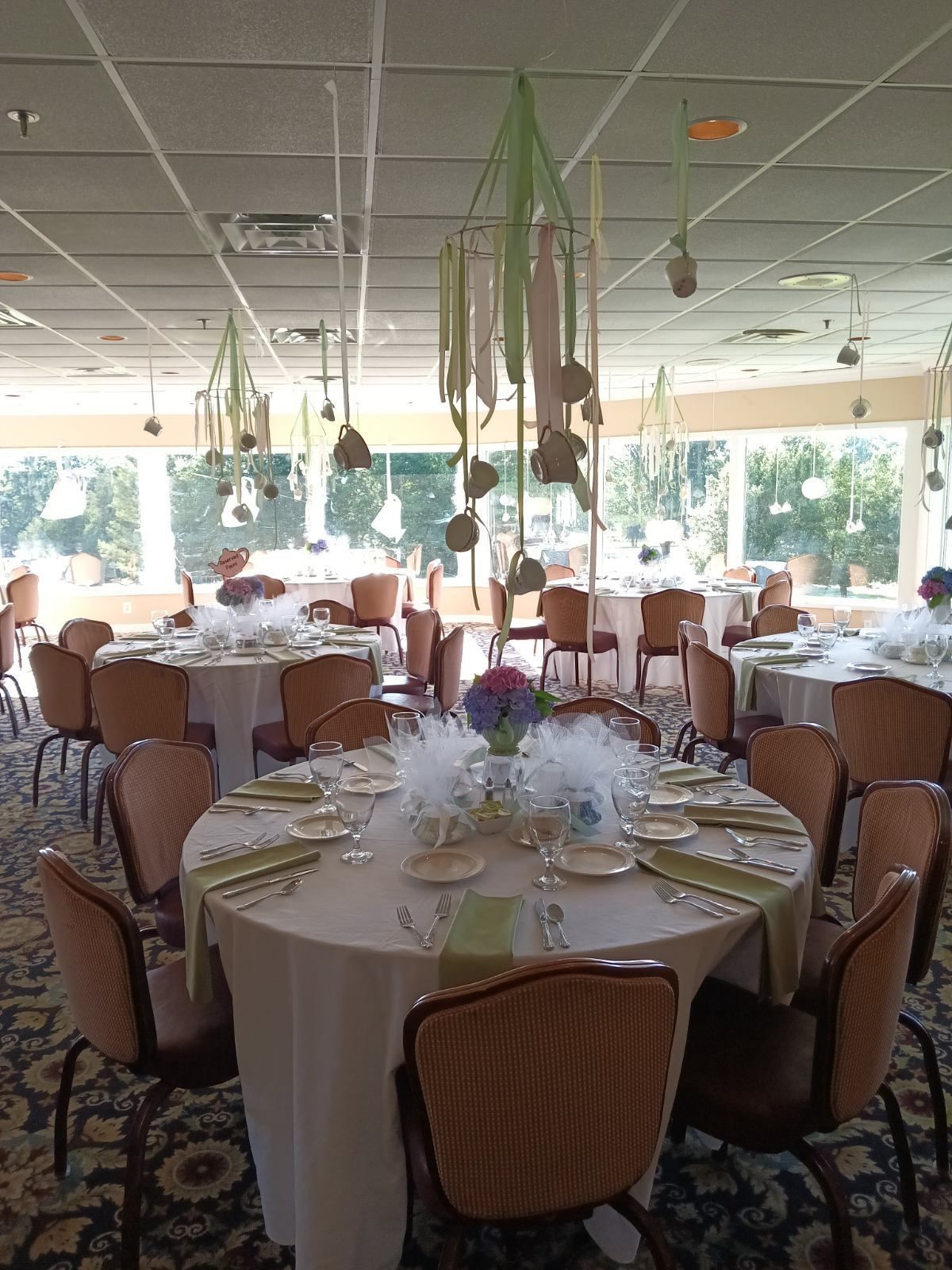 A large room with tables and chairs set up for a wedding reception
