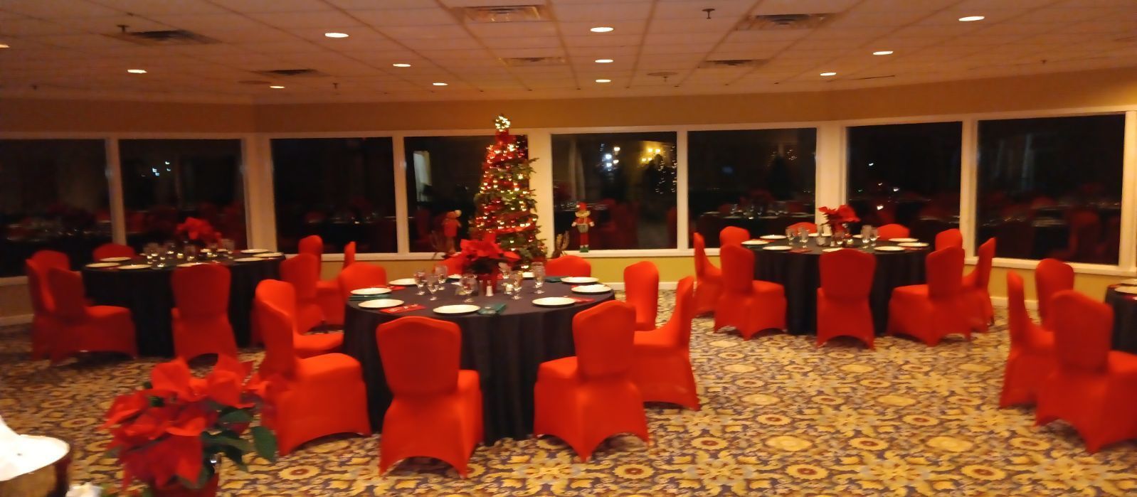 A room with tables and chairs and a christmas tree