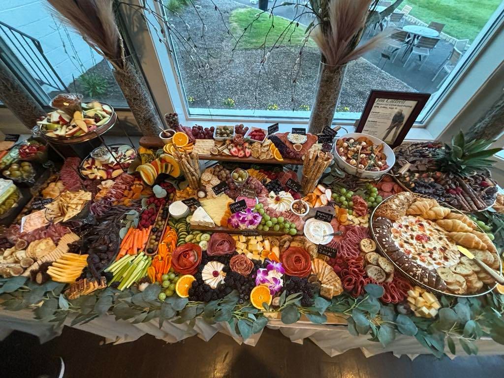 A large platter of food is sitting on a table in front of a window.