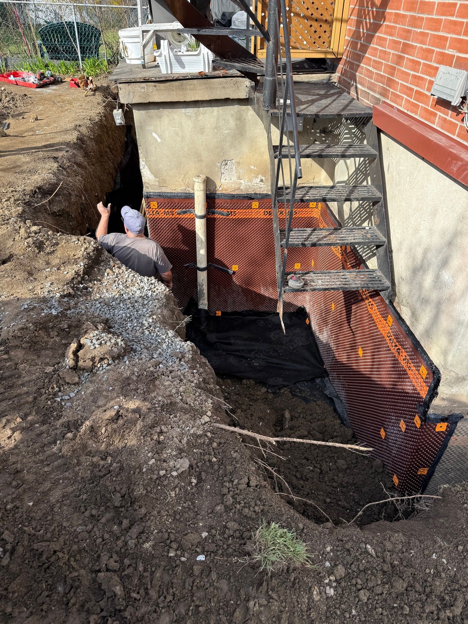 Barrière de drainage en tuyau orange à côté de l'escalier du sous-sol sur un chantier de construction