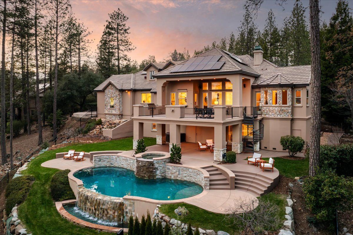 One of the luxury homes in Meadow Vista, CA featuring a resort-style pool, spa, and scenic forest backdrop.