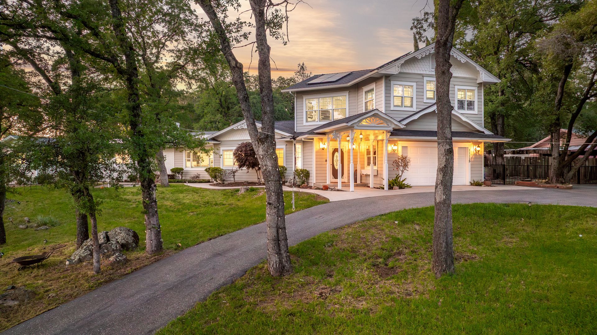 Two-story home with wraparound porch and tree-lined yard listed by a top real estate agent in Auburn, CA.