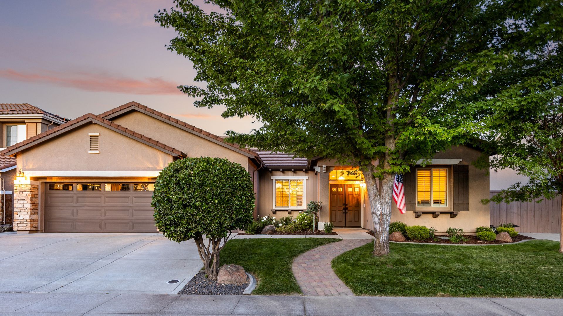Single-story home in Rocklin with a garage, manicured shrubs, and warm sunset lighting.