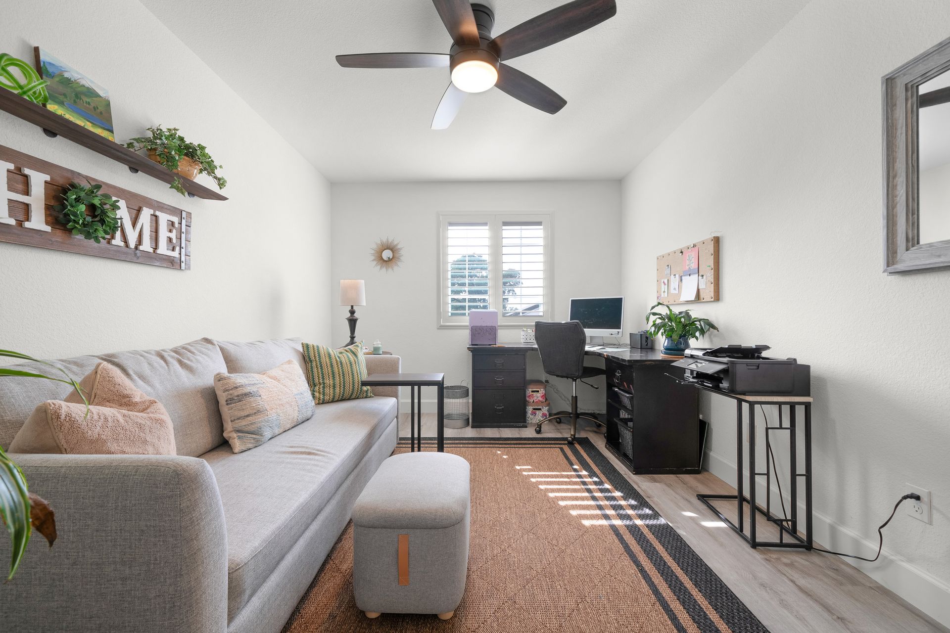 Open-concept living area with modern neutral decor, home office setup, and bright natural lighting throughout.
