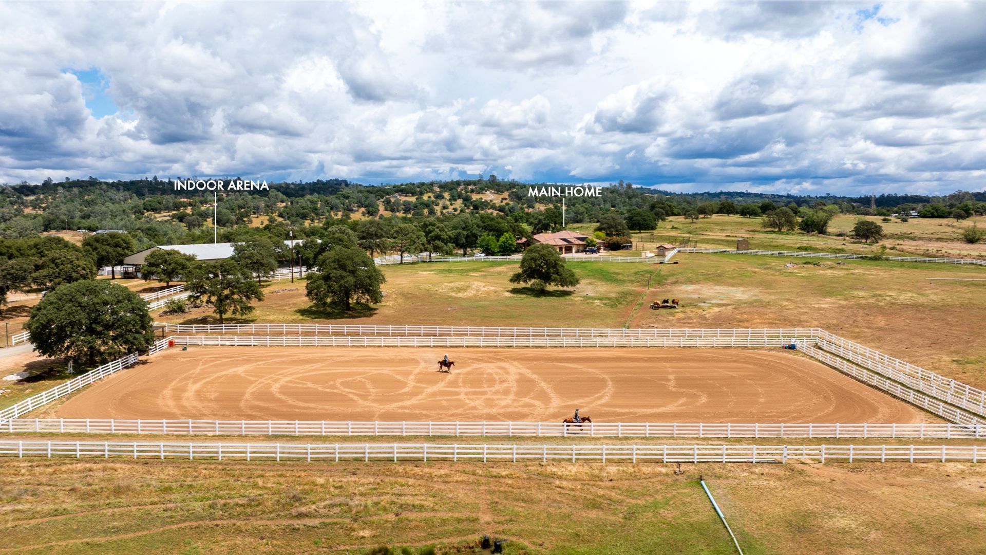 Aerial view of expansive horse property with riding arena and open pastures.