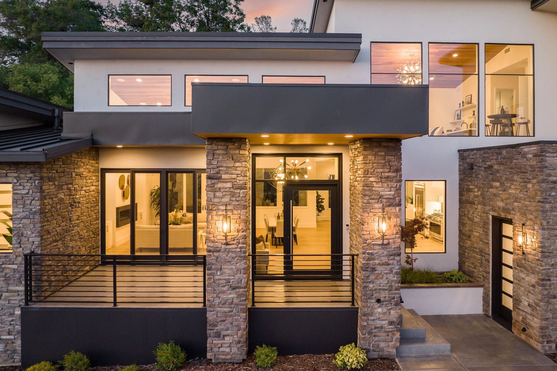 A modern house with a lot of windows and a large porch | Homes for Sale