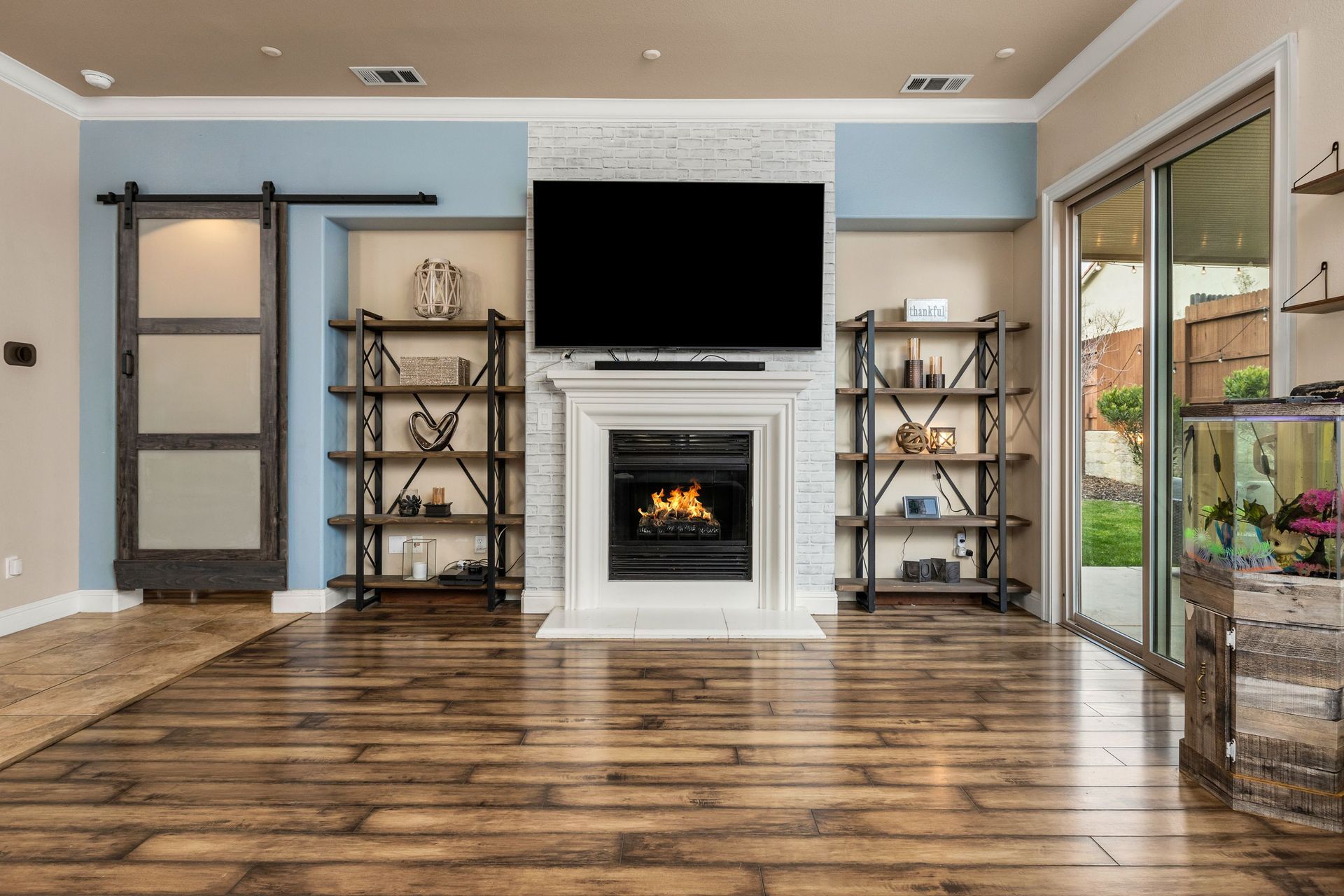 Hardwood-floor living room on La Guardia Circle with fireplace and flat-screen TV.
