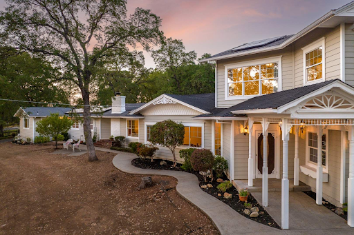 A large house with a porch and a walkway leading to it.