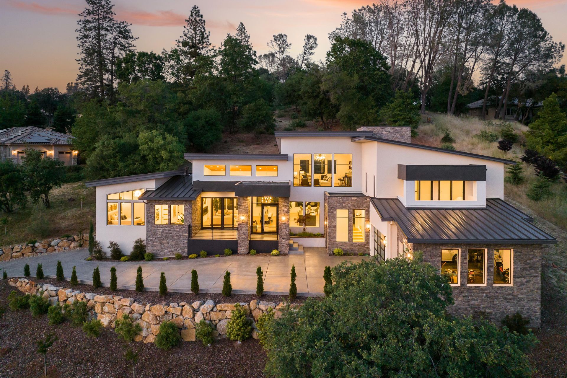 A large house is sitting on top of a hill surrounded by trees | Homes for Sale